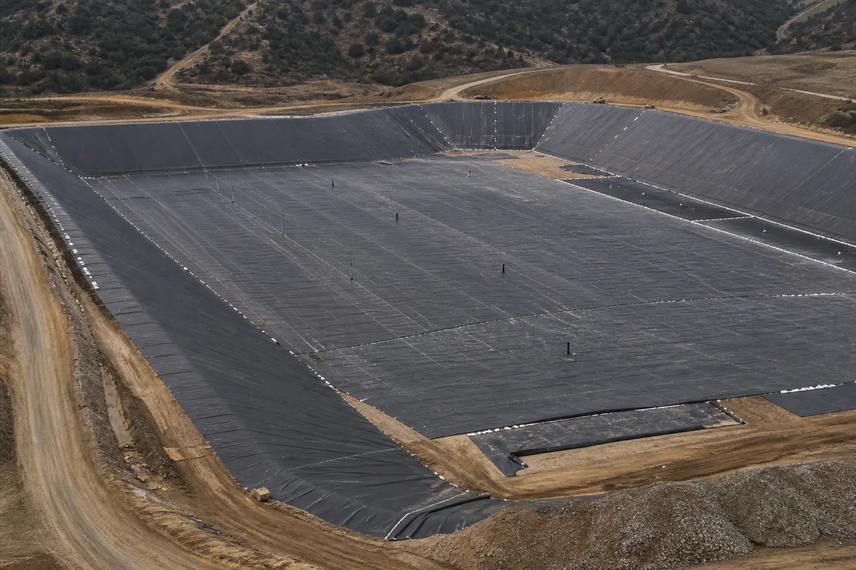 Elevated view of a generic geomembrane-lined containment cell under construction